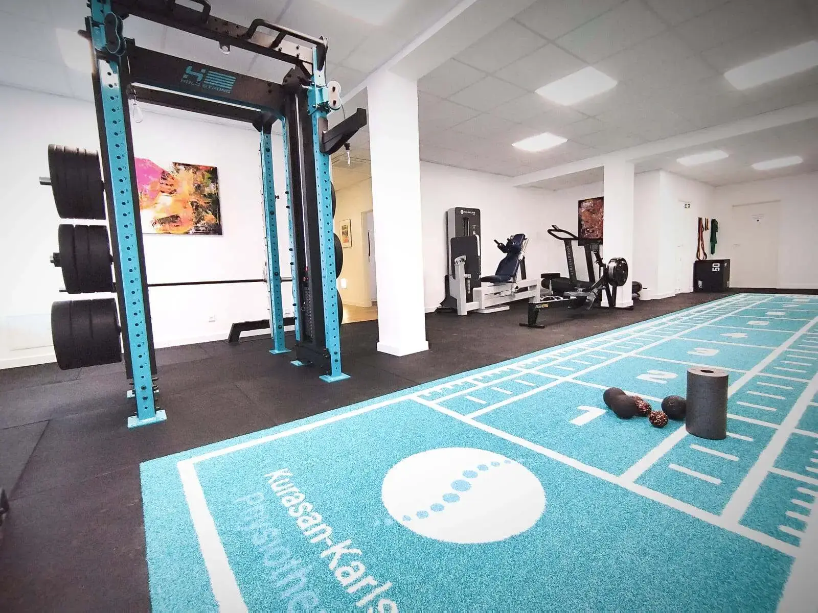 Moderner Trainingsraum mit Geräten und Laufbahn für klassische Krankengymnastik, Reha-Übungen und funktionelles Training