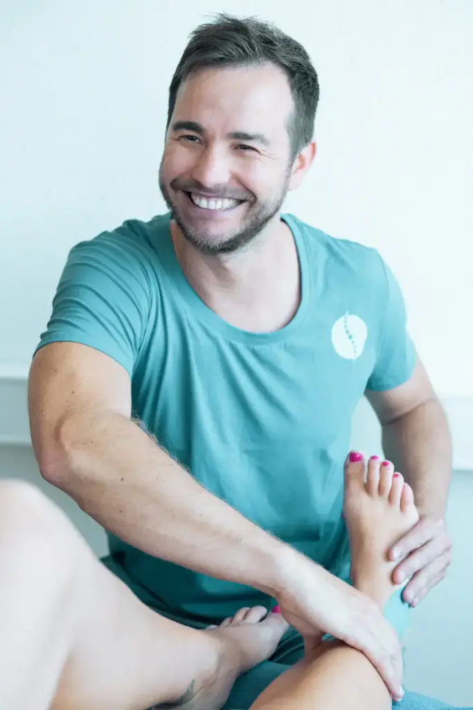 Physiotherapeut führt manuelle Therapie am Sprunggelenk einer Patientin durch, zur Mobilisation und Schmerzlinderung
